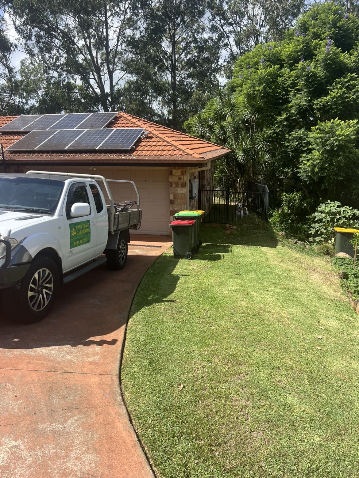 EastCoast Gardening ute parked at a residential lawn mowing job with clippings cleared away