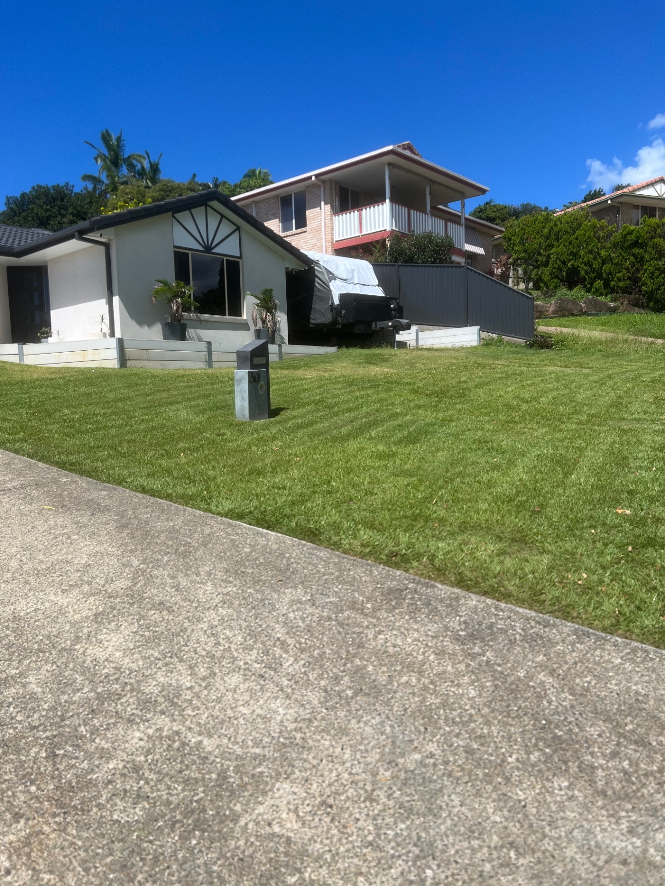 Sloping front lawn mowed and edged neatly in front of a Tweed Coast home